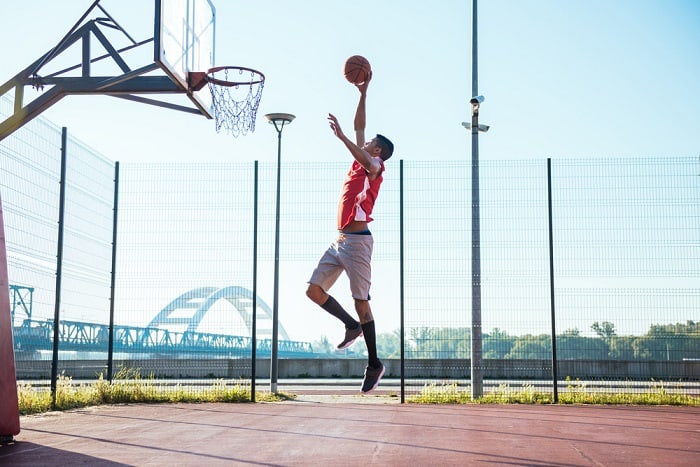 Young basketball player scoring a slam dunk