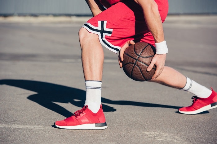 Legs of a basketball players with basketball in hands