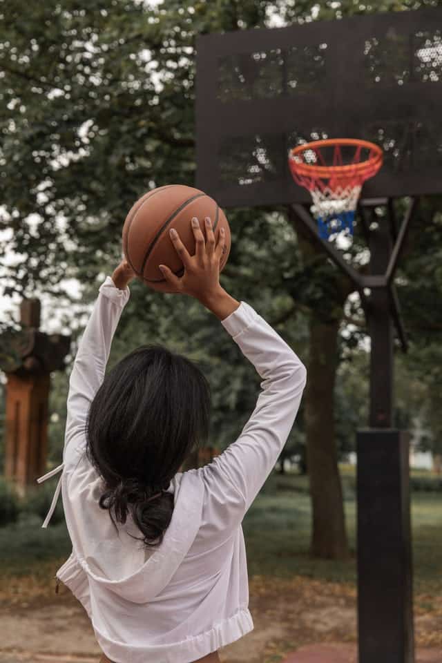 woman shooting basketball towards the hoop
