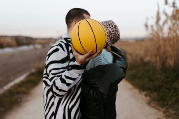 couple kissing on a basketball date